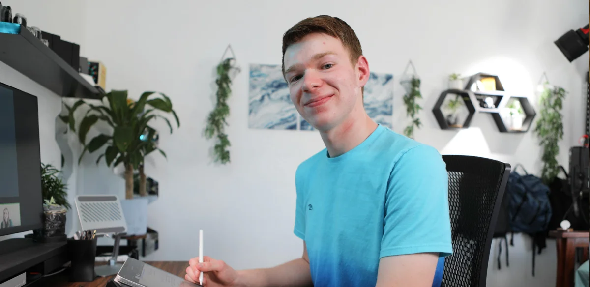 High School student wearing a light bue shirt taking notes at home