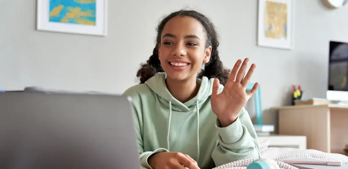 Girl waving at a camera