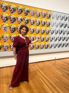 ODLS teacher standing in front of a piece done by Andy Warhol.