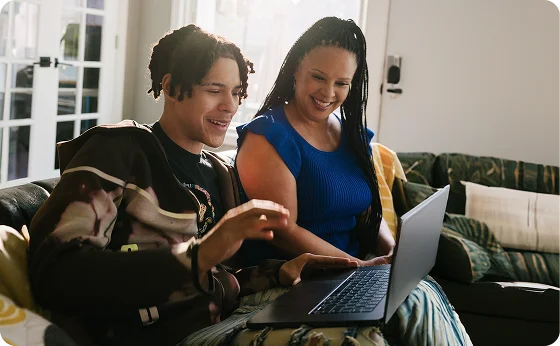 Mother and her son working together with their laptop